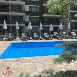 Hotelpool Sirona mit Sonnenliegen, Sonnenschirmen und Steinbelag