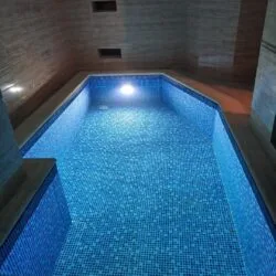 Hallenbad mit Mosaik, Stufe und Unterwasserbeleuchtung